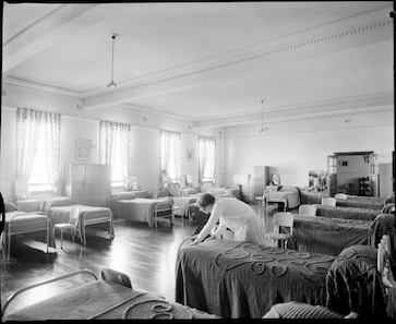 Making a bed in a dormitory at the Home of the Good Shepherd girls home.